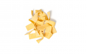 Ein kleiner Stapel ungekochter Pappardelle-Nudeln neben FRoSTA-Tiefkühlprodukten auf weißem Hintergrund.