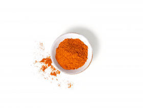 Eine kleine weiße Schüssel gefüllt mit leuchtend orange-rotem Cayennepfeffer-Pulver – perfekt zum Aufpeppen deiner FRoSTA Tiefkühlprodukte.