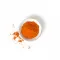 Eine kleine weiße Schüssel gefüllt mit leuchtend orange-rotem Cayennepfeffer-Pulver – perfekt zum Aufpeppen deiner FRoSTA Tiefkühlprodukte.