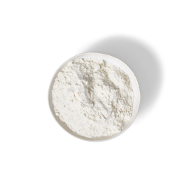 Eine weiße Schüssel mit feinem weißen Pulver, möglicherweise Mehl oder gemahlener Ingwer, neben FRoSTA Tiefkühlprodukten, auf schwarzem Hintergrund.