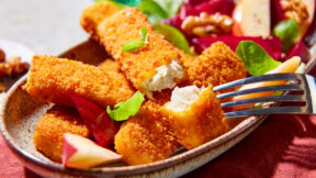 Knusprige FRoSTA Veggie Fischstäbchen auf Teller mit Basilikum und Rote-Bete-Salat aus Apfel, Walnüssen, Roter Bete und Salatblättern.