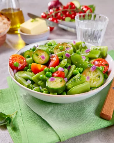 Ein frischer Salat mit Kirschtomaten, Zuckerschoten, Gurken und roten Zwiebeln – perfekt zur FRoSTA Bio Gemüse Pfanne alla Siciliana für ein mediterranes Essen.