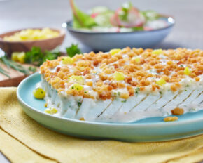 FRoSTA Schlemmerfilet Kartoffel Crème-Auflauf mit goldenen Bröseln, Mais, frischem Salat auf blauem Teller mit gelber Serviette.