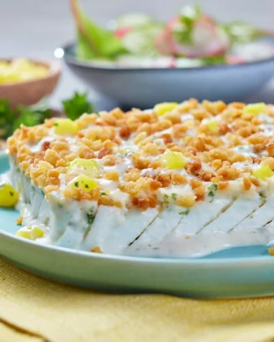 FRoSTA Schlemmerfilet Kartoffel Crème-Auflauf mit goldenen Bröseln, Mais, frischem Salat auf blauem Teller mit gelber Serviette.