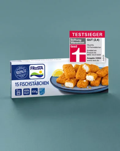 FRoSTA 15 Fischstäbchen FRoSTA auf blauem Untergrund, mit Zitronenstück und Testsieger-Label von Stiftung Warentest oben rechts.