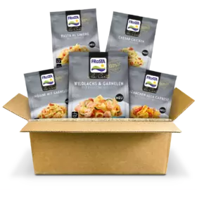 Ein Karton enthält fünf FRoSTA la Carte Tiefkühlprodukte wie Pasta und Hähnchen, stehend als Probierpaket auf weißem Grund.